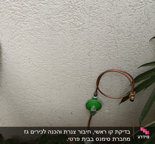 צינור נחושת עם וסת גז ירוק על קיר